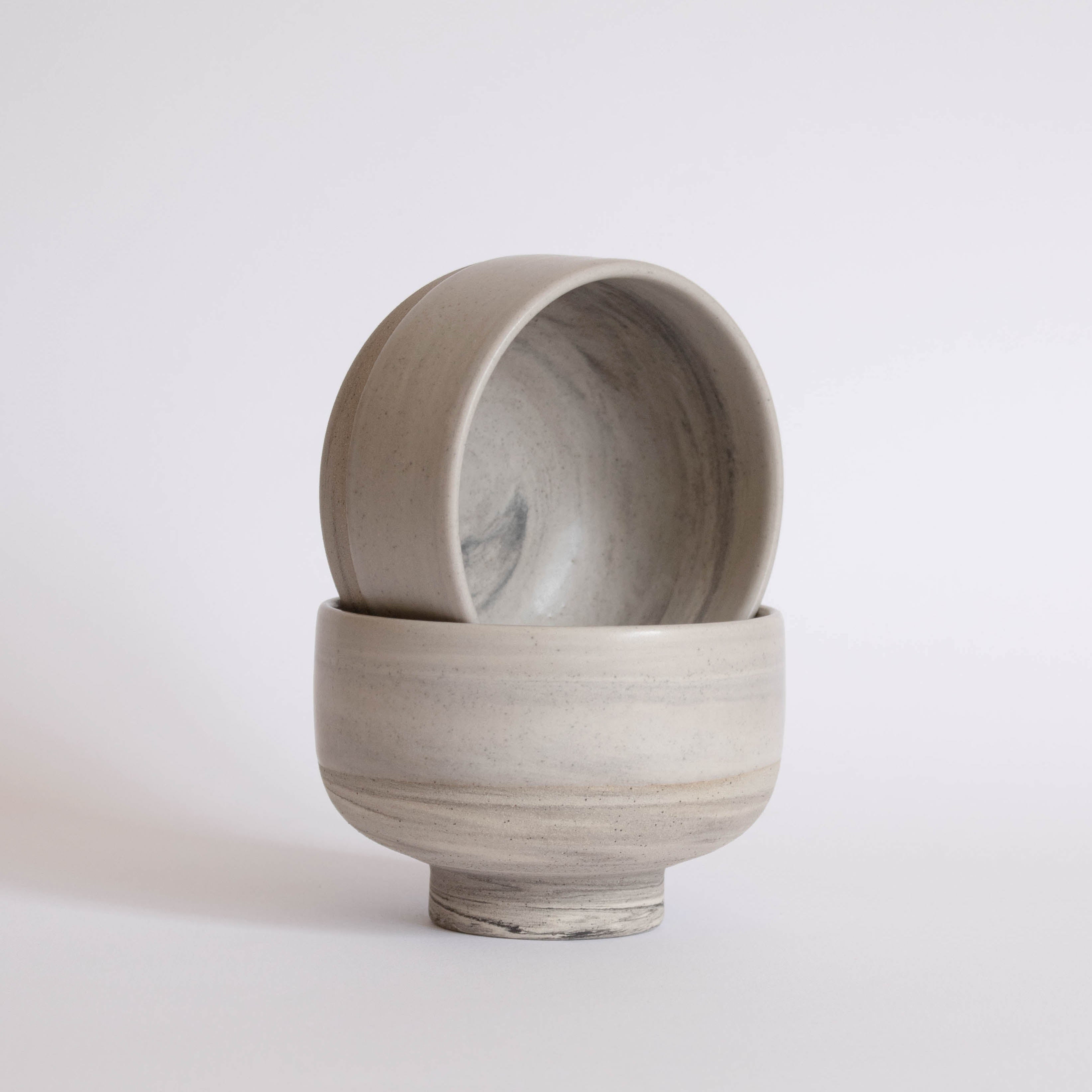 A pair of handmade earthy ice cream bowls against a white background.