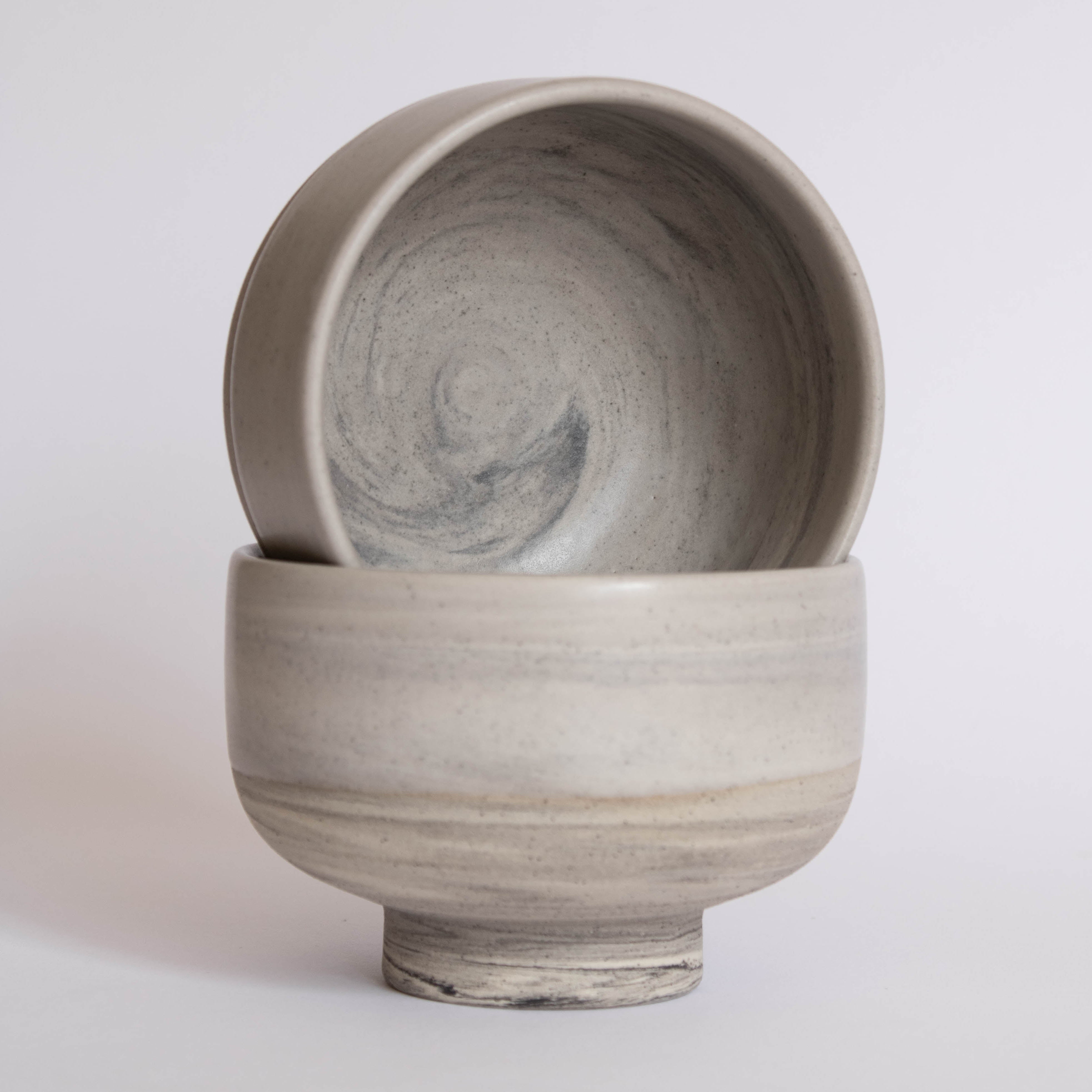 A pair of handmade earthy ice cream bowls against a white background.