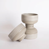 Three handmade earthy-toned ice cream bowls scattered on a white background.