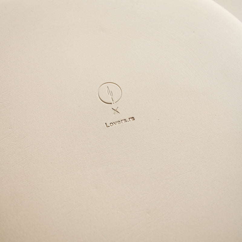 The reverse side of a plate featuring collaboration logos impressed into the clay.