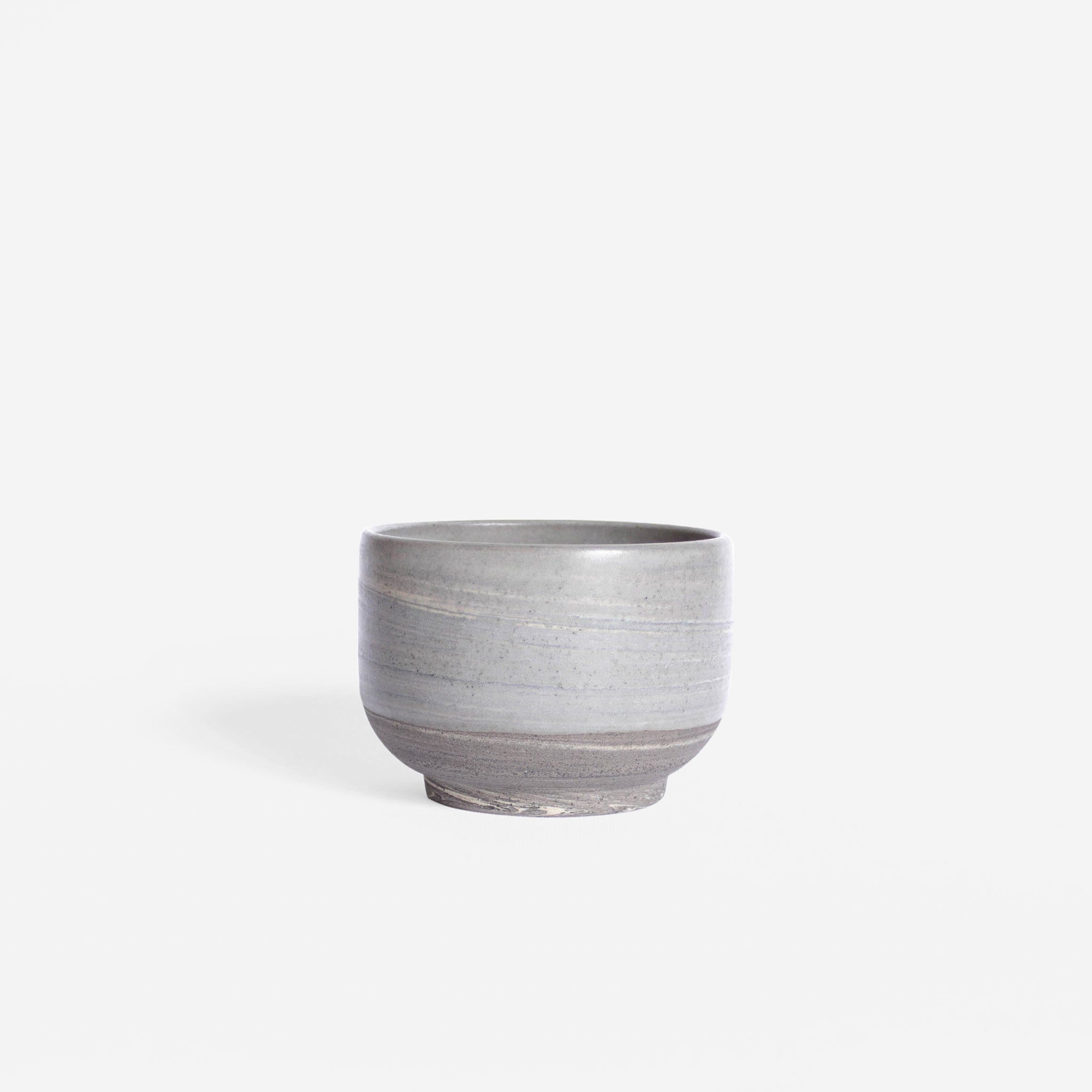 Handmade cappuccino cup featuring a matte marble finish in natural earthy hues, set against a white background.