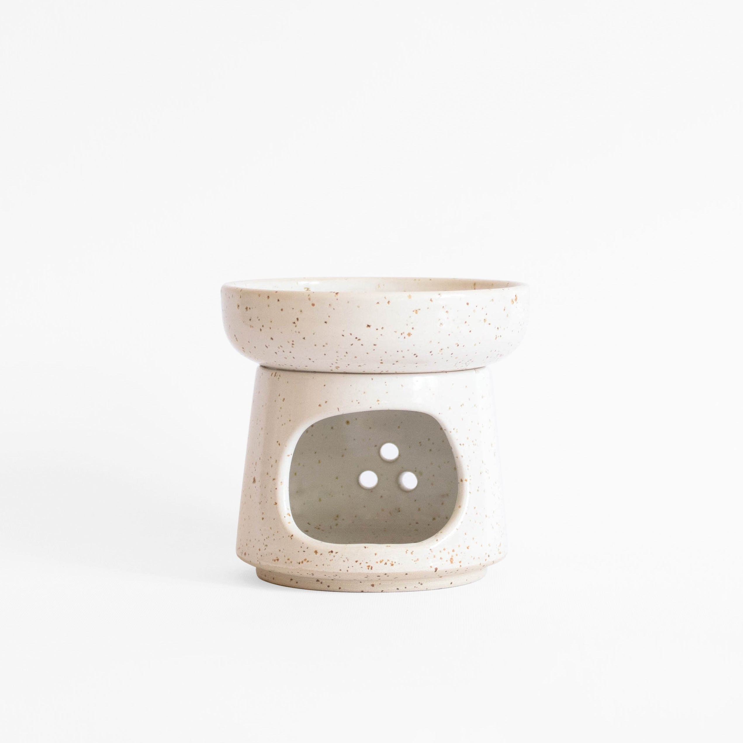A handcrafted ceramic oil burner in speckled white finish, set on a white background.